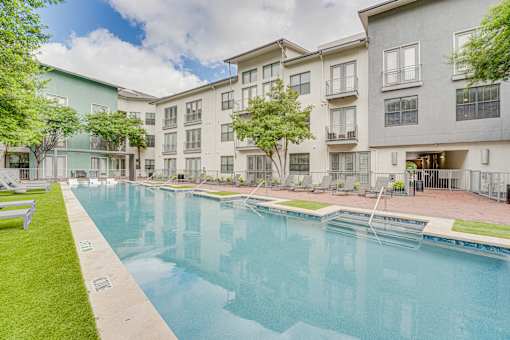 Outdoor swimming pool surrounded by landscaped courtyard at The Montrose Apartments, Texas