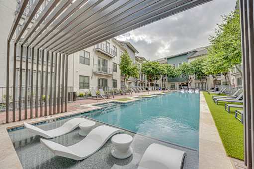Swimming pool with tanning ledge and pergola at The Montrose Apartments, Dallas, TX 75204