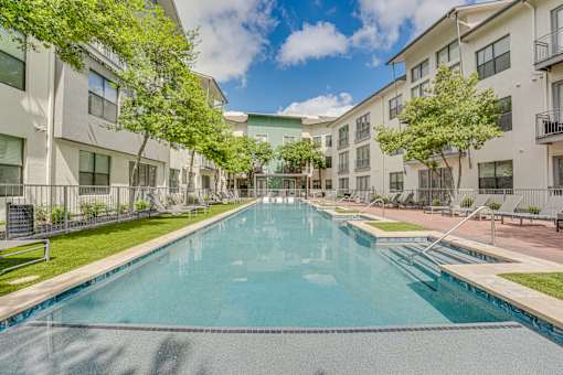 Courtyard pool with sun shelf and seating areas at The Montrose Apartments, Texas