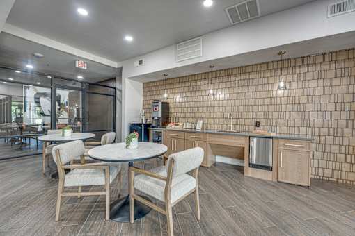 Community kitchen with tile accent wall and seating at The Montrose Apartments, Dallas, Texas