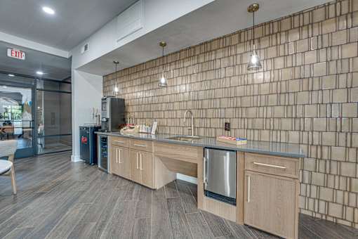 Community kitchen with wood cabinetry and pendant lighting at The Montrose Apartments, Texas