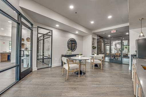 Resident lounge with round tables and glass partitions at The Montrose Apartments, Dallas, TX