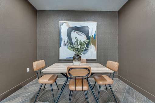 Dining area with modern chairs and abstract artwork at The Montrose Apartments, Dallas, 75204