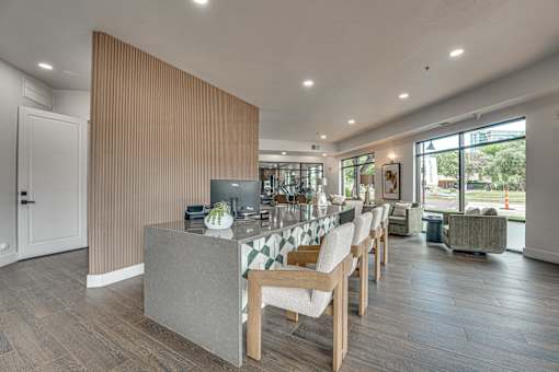 Communal kitchen island with seating and vertical slat partition at The Montrose Apartments, Dallas, Texas