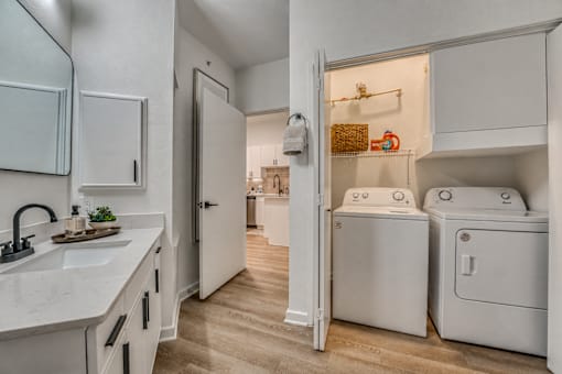Laundry room with washer and dryer in closet at The Montrose Apartments, Dallas, Texas