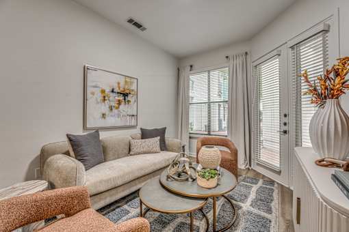 Cozy living room with beige sofa and armchairs at The Montrose Apartments, Dallas, Texas