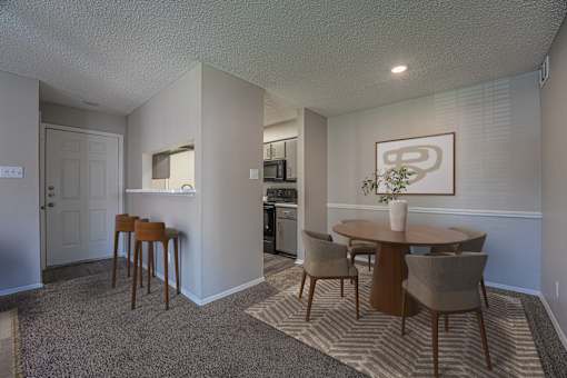 A dining room with a table and chairs.