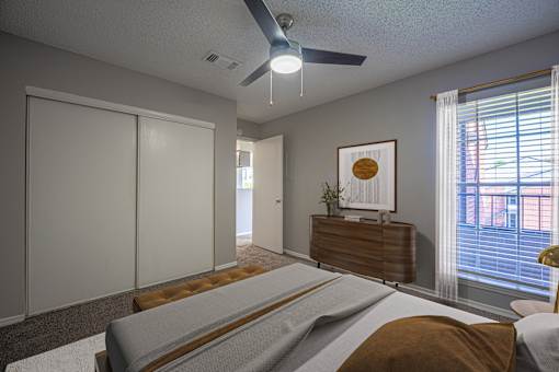 A bedroom with a bed, dresser, and sliding door.