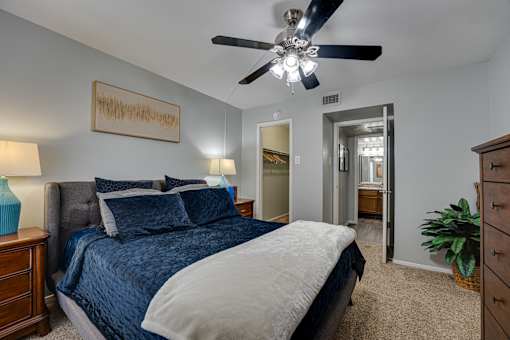 Bedroom with blue bed and fan at Southern Oaks, Fort Worth  