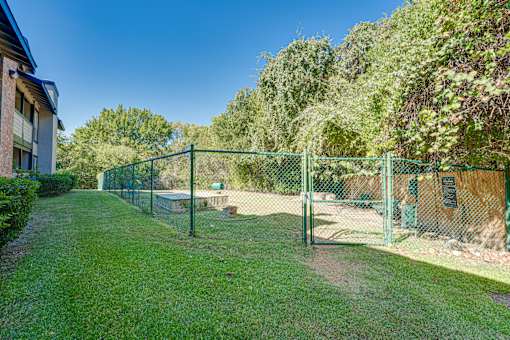 green fence surrounds a grassy at Southern Oaks, Texas
