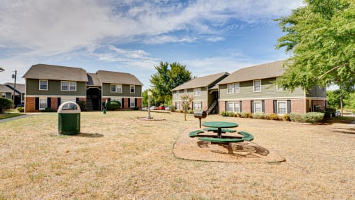 Courtyard area with picnic tables and green space at Arbors Of Cleburne Apartments, Cleburne, Texas