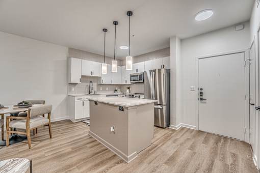 Open concept kitchen with island and pendant lighting at The Barton Apartments, Dallas