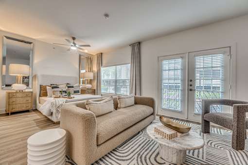 A well-lit, modern bedroom with a large bed and a chair.