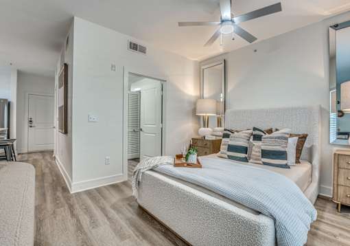 A bedroom with a bed, dresser, and mirror.