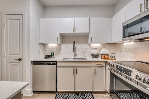 A kitchen with white cabinets and a stainless steel oven.