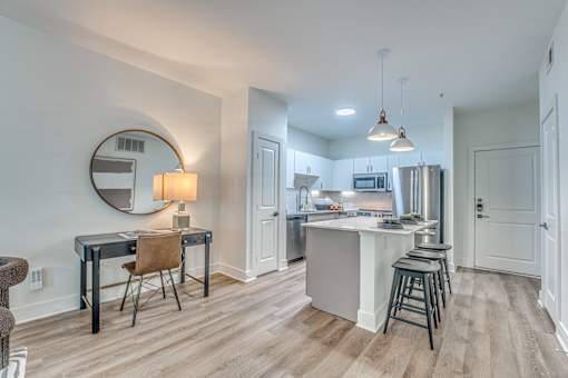 A kitchen with a bar stool and a table with a chair.