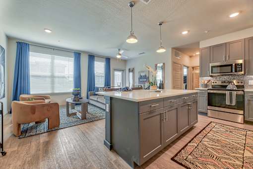 A modern kitchen with a large island and a dining area.