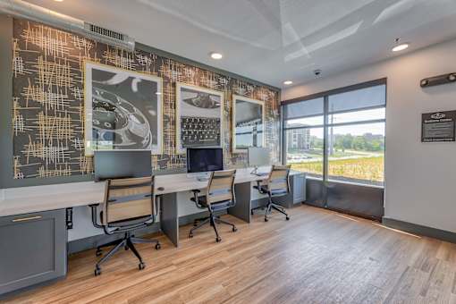 A modern office space with a long table and chairs, a patterned wall, and a view of the outdoors.