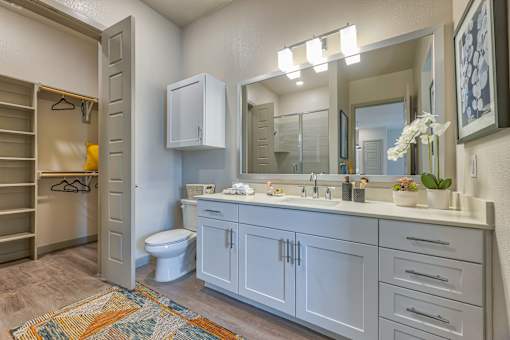 A bathroom with a toilet, sink, and a mirror.