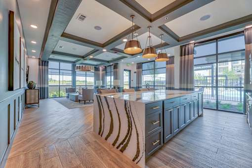 A modern kitchen with a large island and pendant lights.