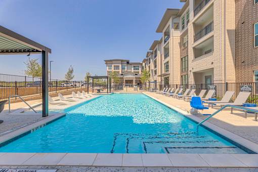 A swimming pool in front of apartment buildings.