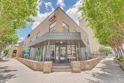 Leasing center exterior with stone base and entrance at Vue Live Oak Apartments, Dallas