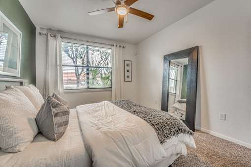 Bedroom with large mirror and natural light at Vue Live Oak Apartments, Texas, 75204