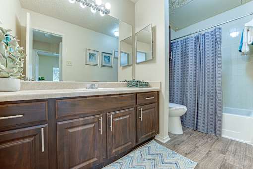 A bathroom with a wooden vanity and a white toilet. at Wilson Crossing, Texas