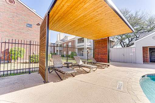 A wooden covered patio area with a pool and lounge chairs. at Wilson Crossing, Cedar Hill, 75104