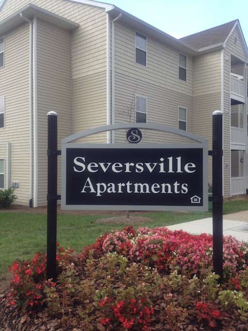 A sign for Seversville Apartments is in front of a building.