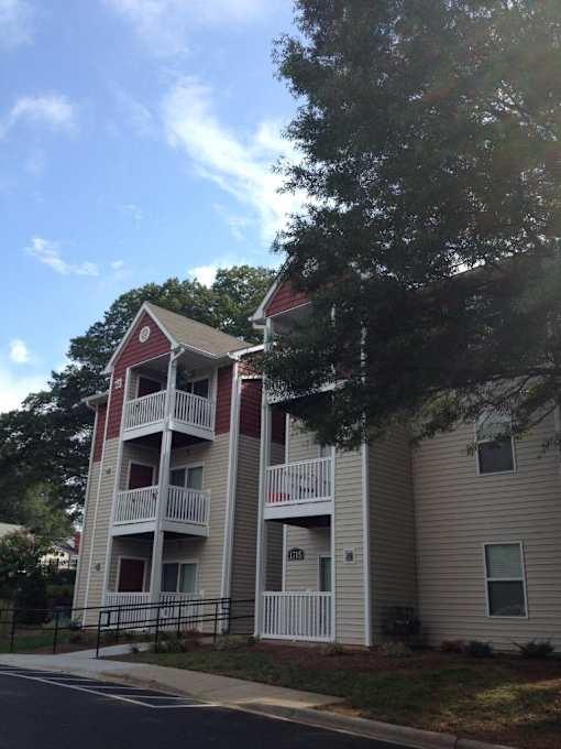 Apartment building with a red roof and white balconies.