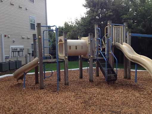 A playground with a slide, swings, and a tunnel.