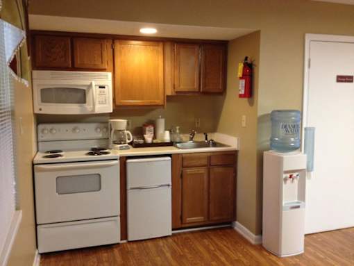 A kitchen with white appliances and wooden cabinets.