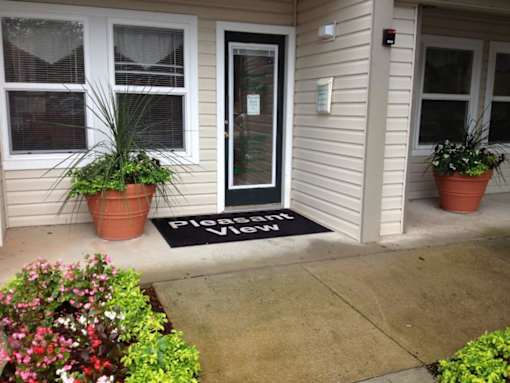 A house entrance with a doormat that says "Please knock".