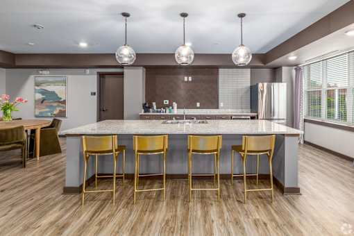 A kitchen with a bar area and chairs.