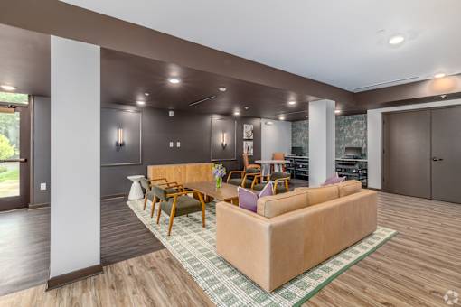 A living room with a couch, chairs, and a rug.