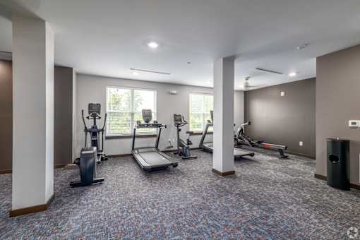 A spacious gym with treadmills, elliptical machines, and other exercise equipment.