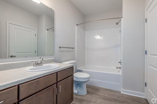 A white bathroom with a toilet, sink, and bathtub.