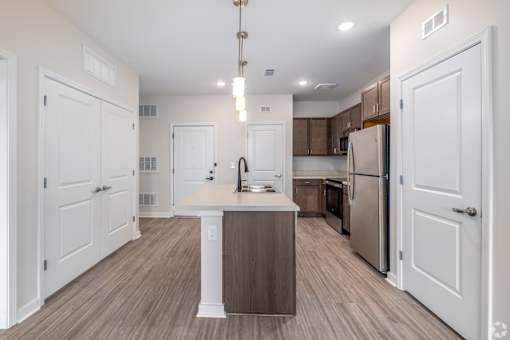 A kitchen with white cabinets and a wooden island.