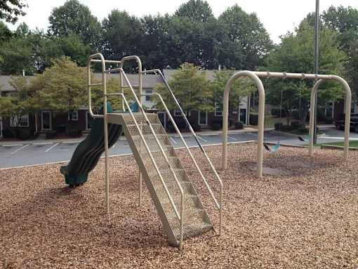 A playground with a slide and monkey bars.