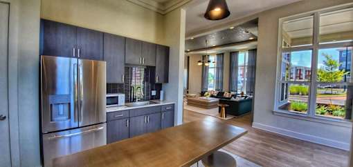 A modern kitchen with stainless steel appliances and wooden floors.