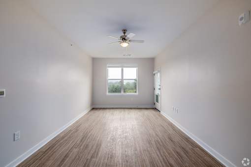 A room with a ceiling fan and a window.