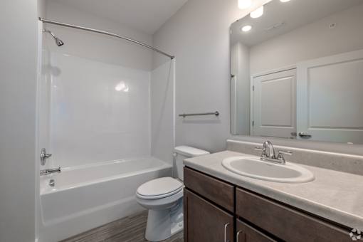 A white bathroom with a toilet, sink, and bathtub.