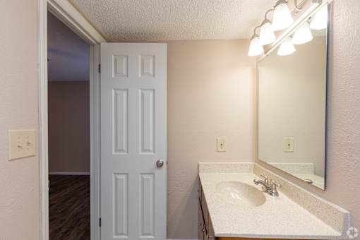 A bathroom with a white sink and a white door.