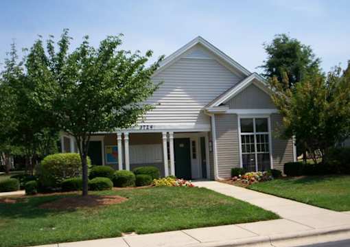 A small house with a green lawn in front.