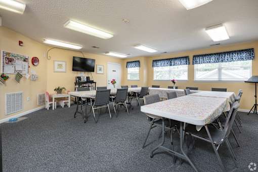 A room with tables and chairs set up for an event.