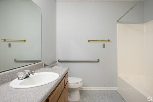 A bathroom with a sink, toilet, and bathtub.