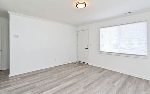 A room with a white door and a window with blinds.