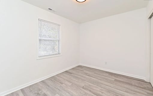 A room with a framed document on the wall and a light on the ceiling.