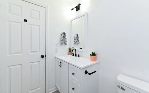 A white bathroom with a sink and a toilet.